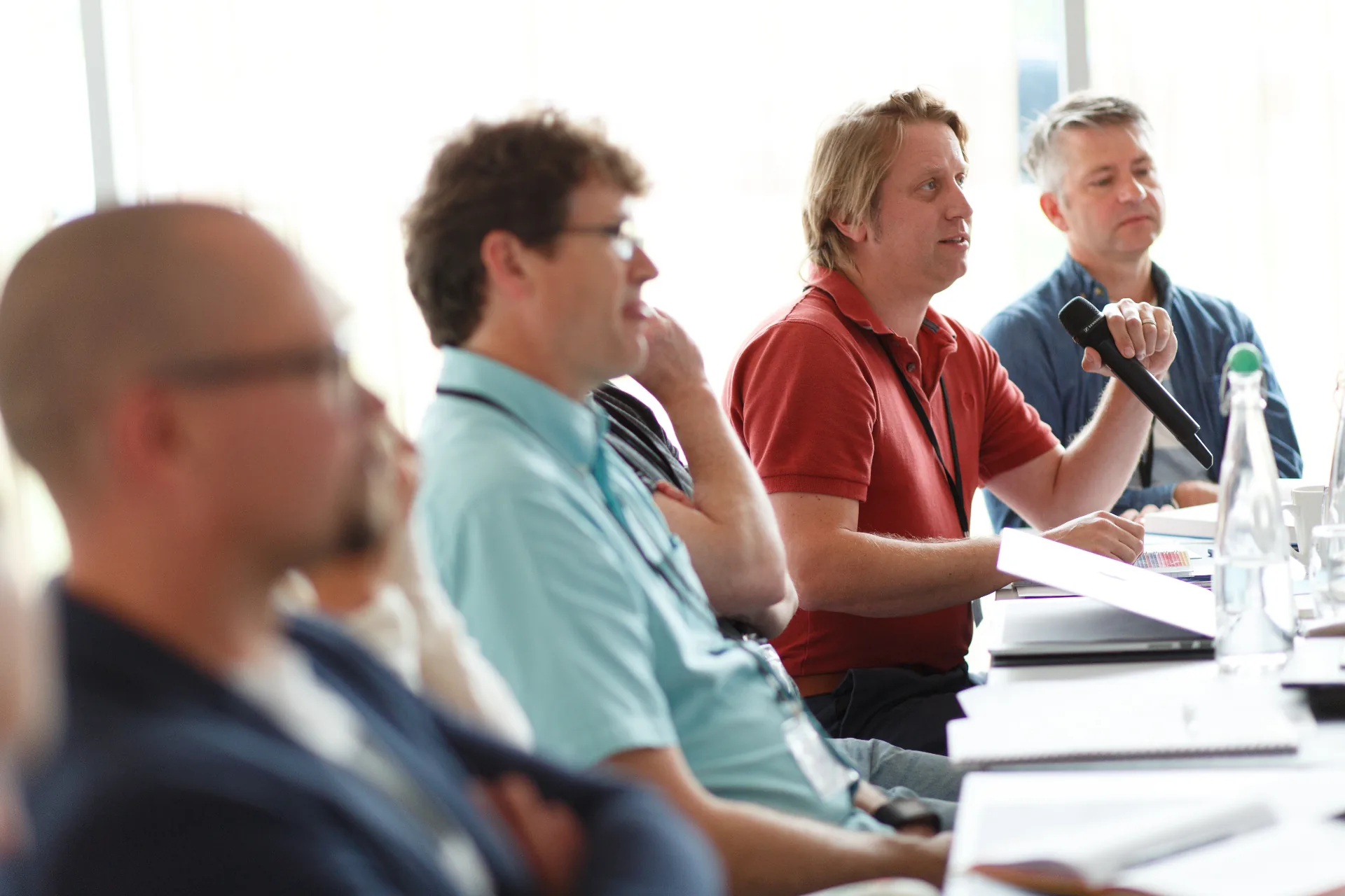 Workshop attendees engaged in discussion with microphone
